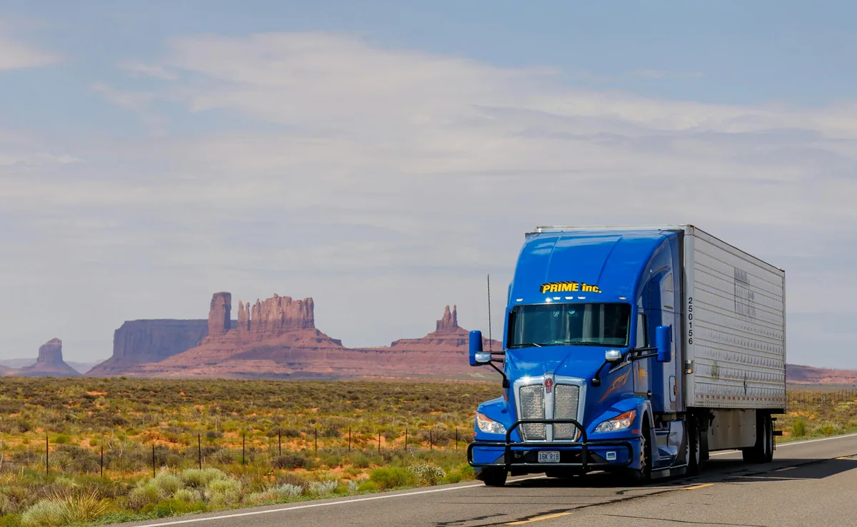 Semi truck hauling dry van freight on a desert highway, motor truck cargo insurance coverage guide